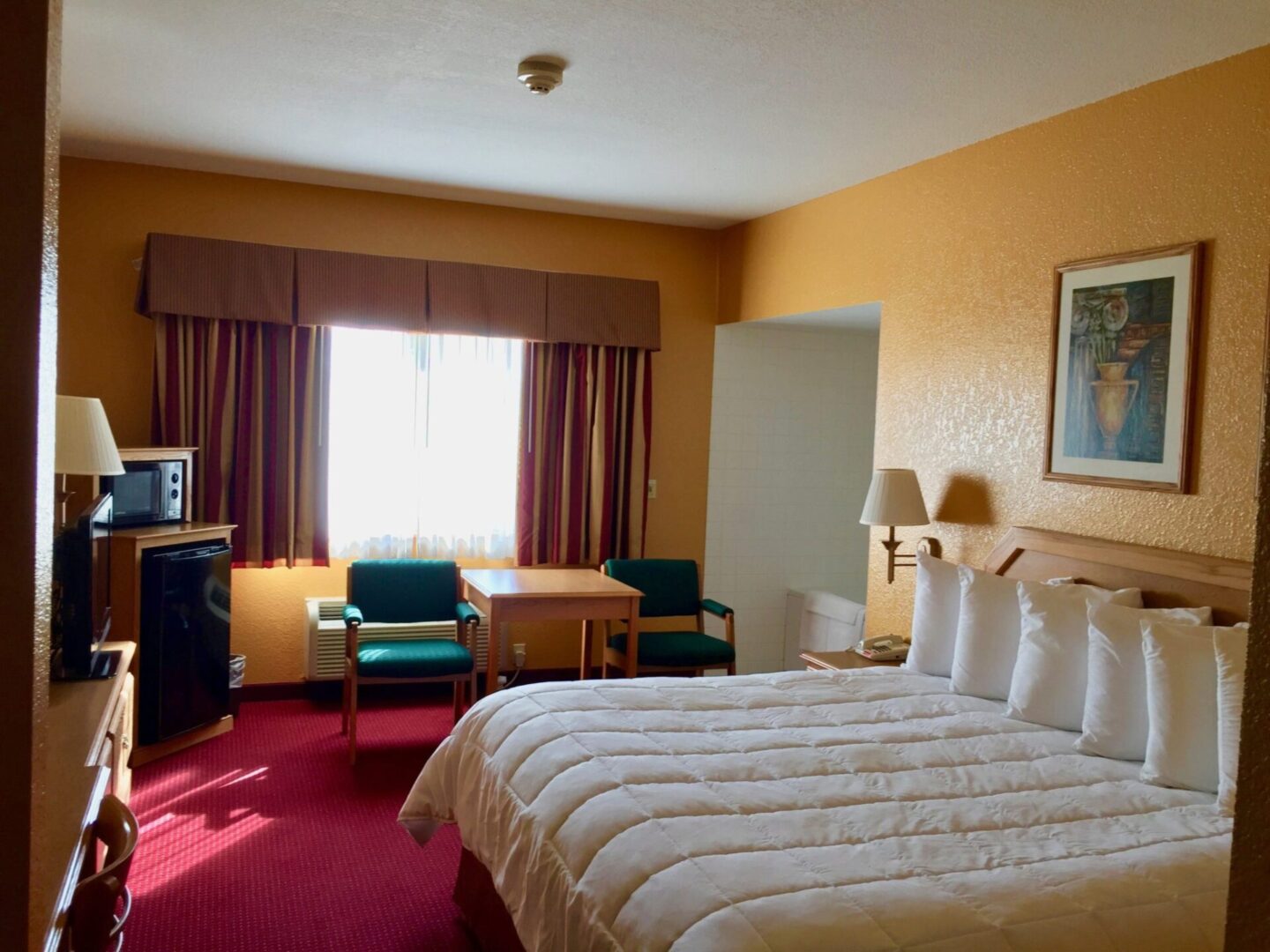 Hotel bedroom with a wide window along with a big bed