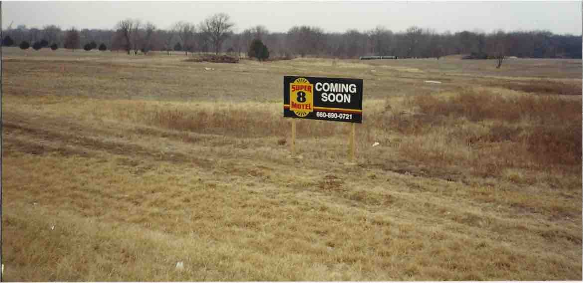 Supra Motel coming soon sign board in an open field