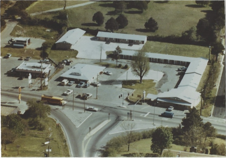 Top angle full pic of a hotel with road and vehicles on it