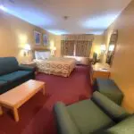 A view of a Hotel room with a couch and TV at Parkfield.