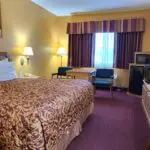 A Parkfield hotel room with a bed, desk and television.