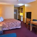 A Hotel room in Parkfield with a bed, desk, and television.