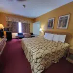 A Hotel room in Parkfield with a bed, desk and television.