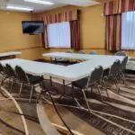 A meeting room with a large table and chairs at Parkfield Hotel.