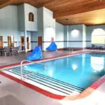 Parkfield Hotel's indoor pool is equipped with comfortable chairs and tables.