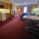 A room in a motel with a desk, chair and tv at Parkfield Hotel.